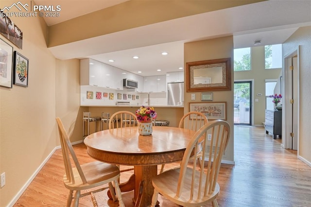 dining area featuring light wood finished floors, recessed lighting, and baseboards