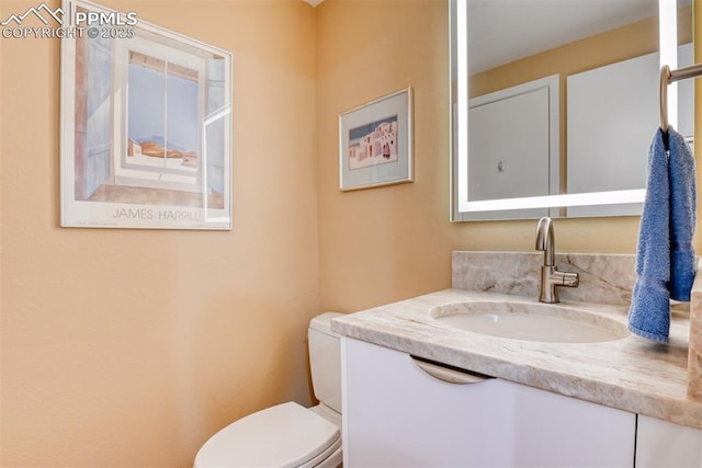 half bathroom with vanity and toilet