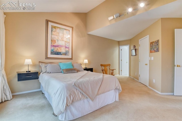 bedroom featuring light colored carpet, vaulted ceiling, and baseboards