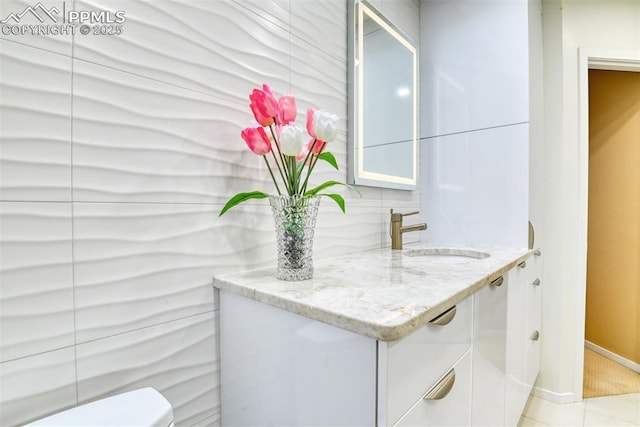 bathroom with baseboards, toilet, tile patterned flooring, vanity, and backsplash