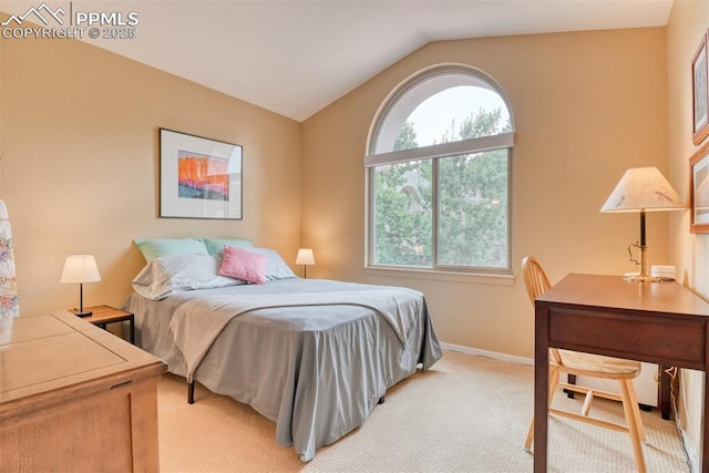 bedroom with light colored carpet, vaulted ceiling, and baseboards