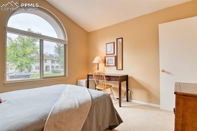 carpeted bedroom featuring lofted ceiling and baseboards