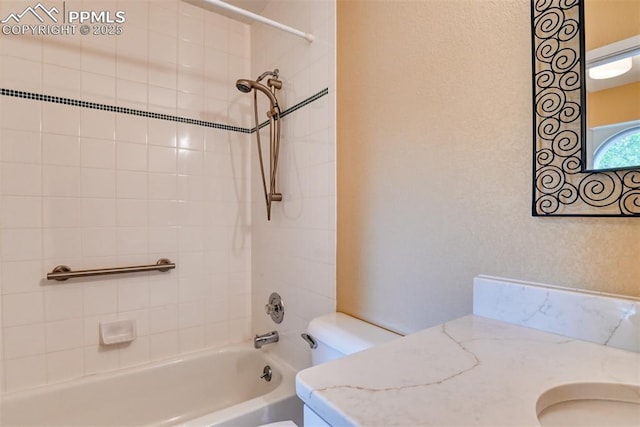 bathroom featuring toilet, vanity, and bathing tub / shower combination