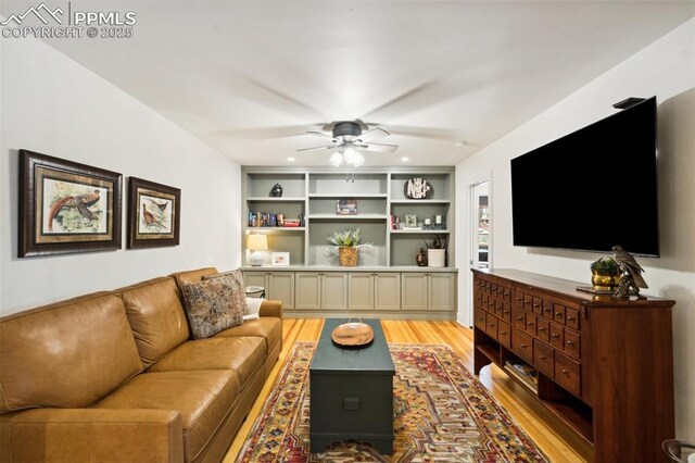 living room featuring light wood-style flooring, a ceiling fan, and recessed lighting
