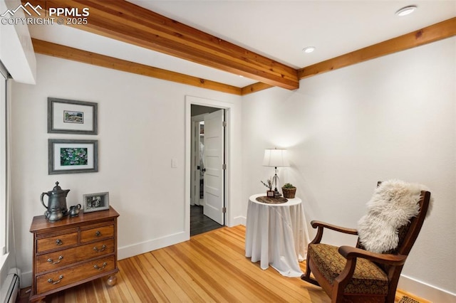 living area with beamed ceiling, wood finished floors, a baseboard heating unit, baseboards, and recessed lighting