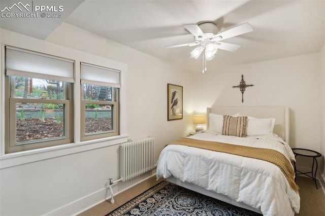 bedroom featuring radiator heating unit, carpet floors, baseboards, and ceiling fan