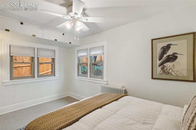 carpeted bedroom with radiator heating unit, baseboards, and a ceiling fan