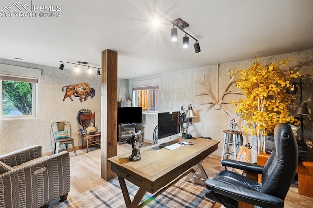 office with track lighting, wood finished floors, and wallpapered walls