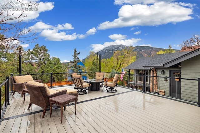 deck featuring a mountain view and an outdoor fire pit