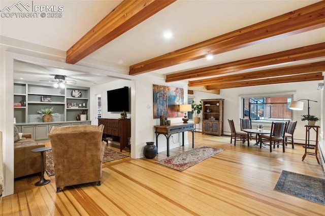 living area featuring light wood-style flooring, beam ceiling, and a ceiling fan