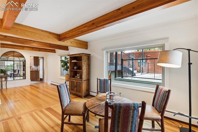 dining room with a baseboard radiator, light wood-style flooring, a baseboard heating unit, and beamed ceiling