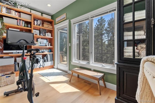 interior space with baseboards, visible vents, and wood finished floors