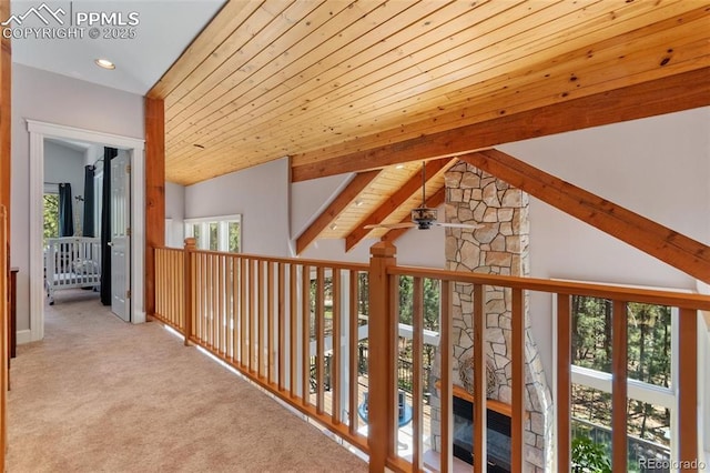 corridor with carpet floors, wood ceiling, and lofted ceiling with beams