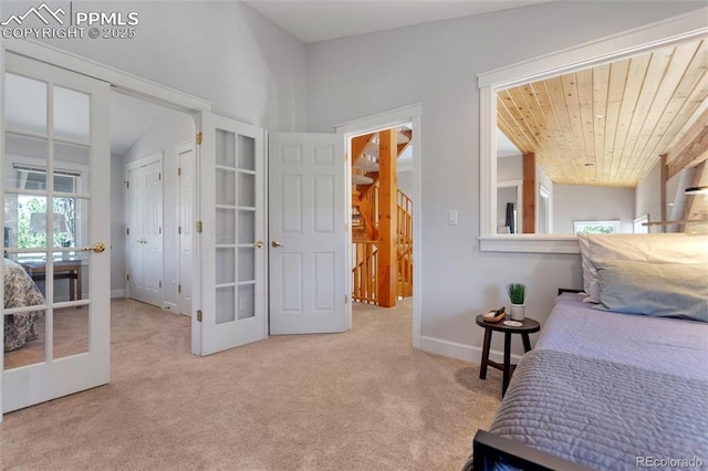 carpeted bedroom featuring french doors and baseboards