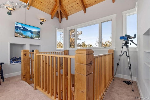 corridor with light colored carpet, lofted ceiling with beams, wood ceiling, an upstairs landing, and baseboards