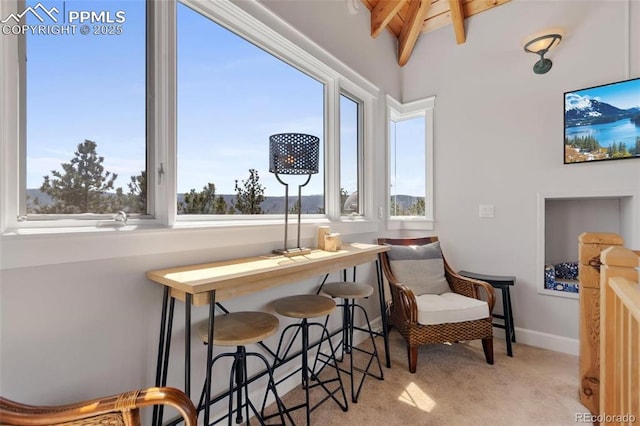 living area featuring lofted ceiling with beams, carpet, and baseboards