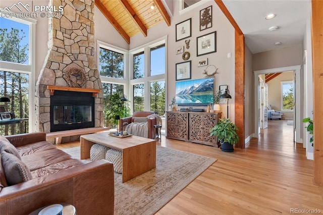 living area with wooden ceiling, wood finished floors, a fireplace, high vaulted ceiling, and beam ceiling