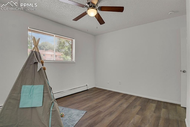 1073 Westmoreland Rd, Colorado Springs, CO 80907 - unfurnished room featuring baseboards, a textured ceiling, baseboard heating, and wood finished floors
