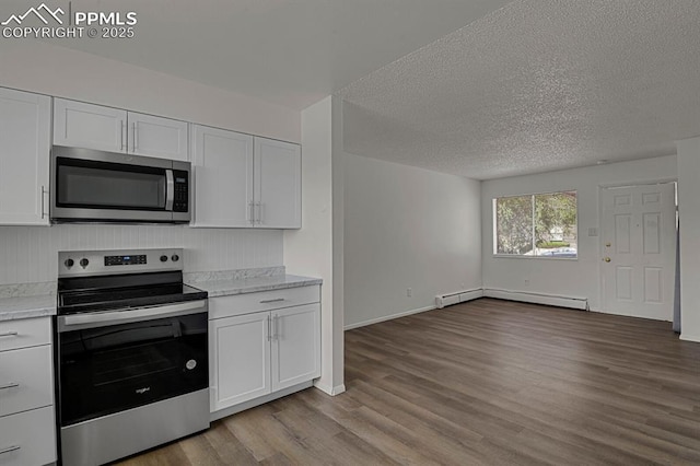 1073 Westmoreland Rd, Colorado Springs, CO 80907 - kitchen with white cabinets, open floor plan, stainless steel appliances, light countertops, and a baseboard heating unit