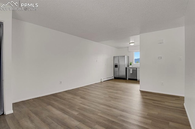 1073 Westmoreland Rd, Colorado Springs, CO 80907 - unfurnished living room with a baseboard heating unit, a textured ceiling, dark wood finished floors, and baseboards