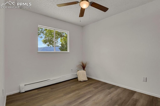 1073 Westmoreland Rd, Colorado Springs, CO 80907 - spare room with baseboards, a baseboard radiator, ceiling fan, wood finished floors, and a textured ceiling