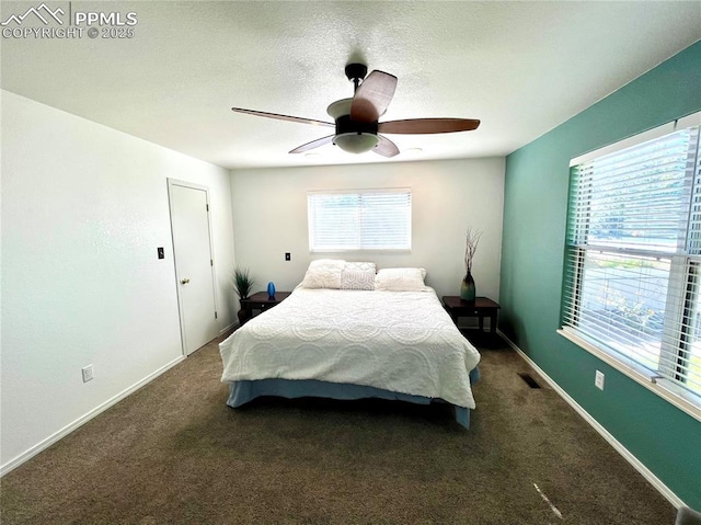 carpeted bedroom featuring ceiling fan, multiple windows, visible vents, and baseboards