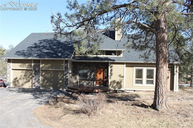 view of front of house with an attached garage, aphalt driveway, a shingled roof, and a wooden deck