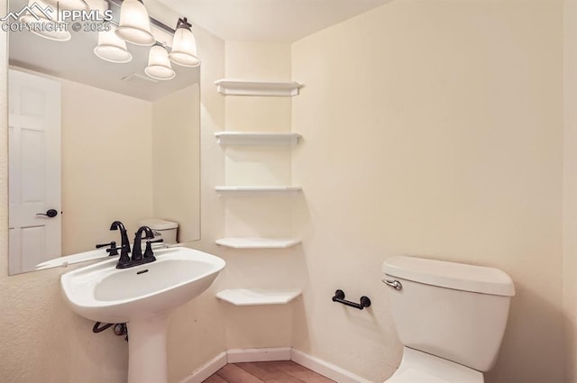 bathroom featuring baseboards, toilet, and wood finished floors