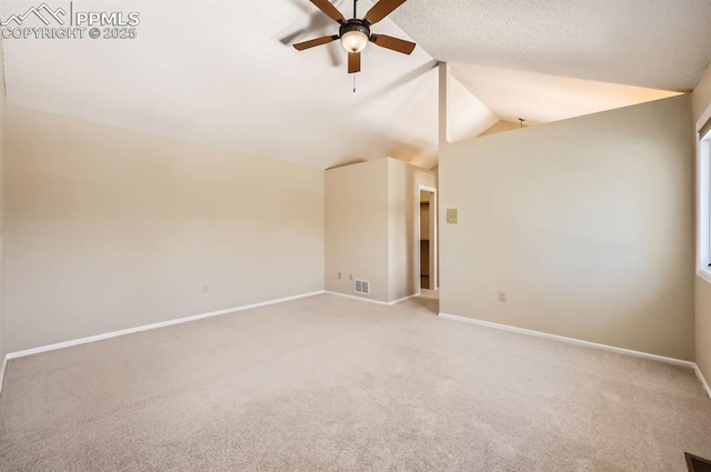 unfurnished room with lofted ceiling, ceiling fan, baseboards, and carpet flooring