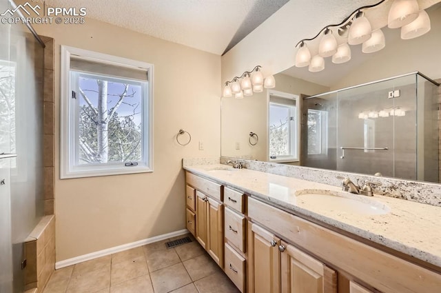 full bathroom with double vanity, tile patterned flooring, a sink, and a shower with shower door