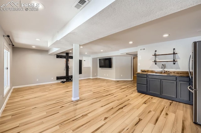 exercise area with recessed lighting, a sink, visible vents, baseboards, and light wood-type flooring