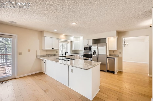 kitchen featuring a peninsula, light wood-style flooring, white cabinetry, and stainless steel appliances