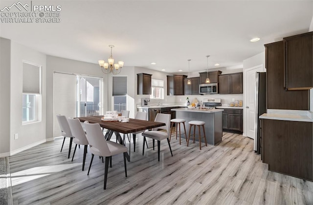 dining area with recessed lighting, a notable chandelier, light wood-style flooring, and baseboards