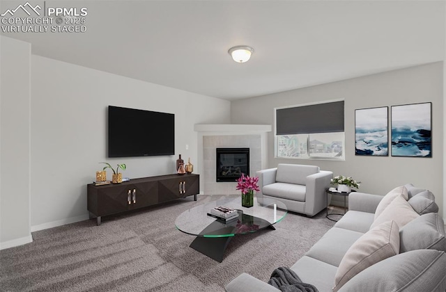 living room featuring a tile fireplace, baseboards, and carpet