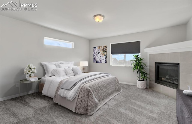 bedroom with carpet floors, baseboards, and a tile fireplace