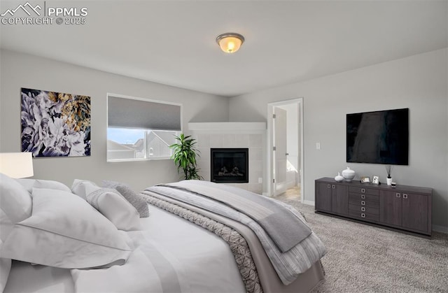 bedroom with carpet floors, baseboards, and a tiled fireplace