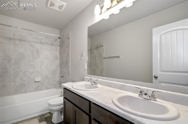 bathroom with double vanity, shower / washtub combination, a sink, and toilet