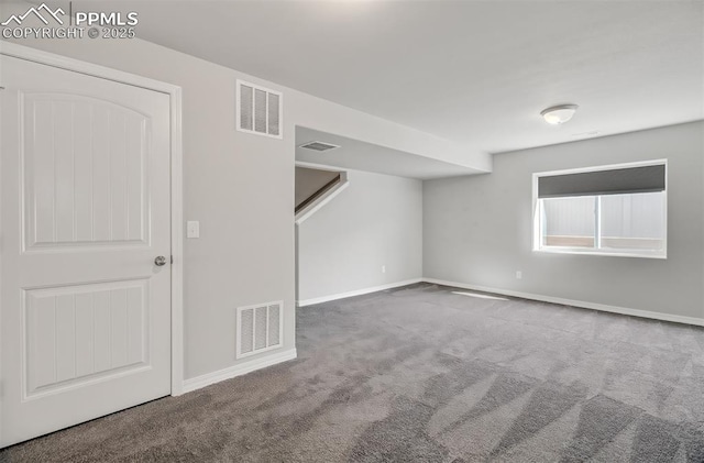 spare room with carpet floors, visible vents, and baseboards