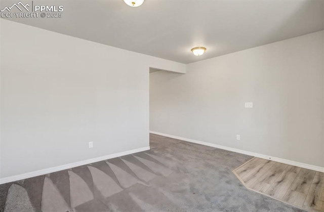 empty room featuring carpet and baseboards