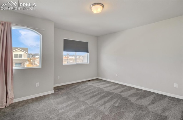 carpeted spare room featuring baseboards