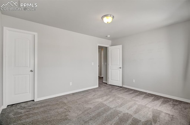 unfurnished room featuring carpet floors and baseboards