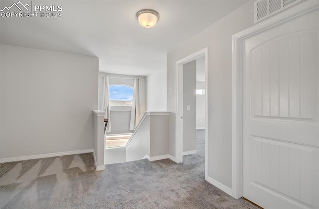 corridor featuring visible vents, carpet flooring, an upstairs landing, and baseboards