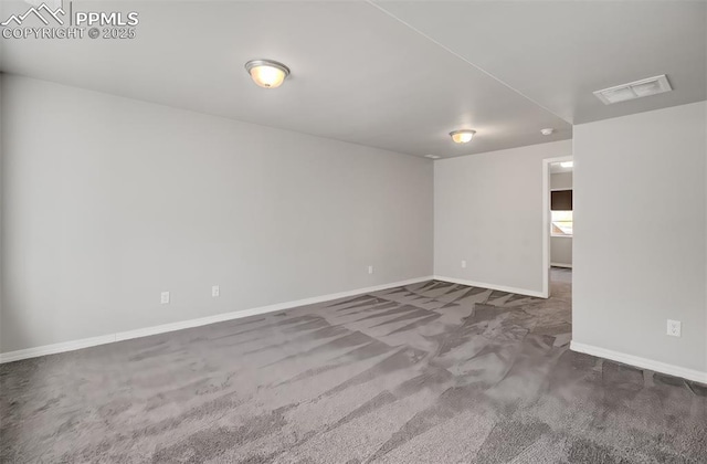 spare room with carpet, visible vents, and baseboards