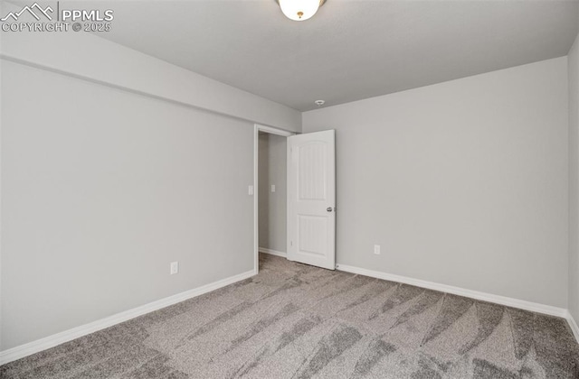 carpeted empty room featuring baseboards