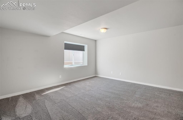 spare room featuring carpet floors and baseboards