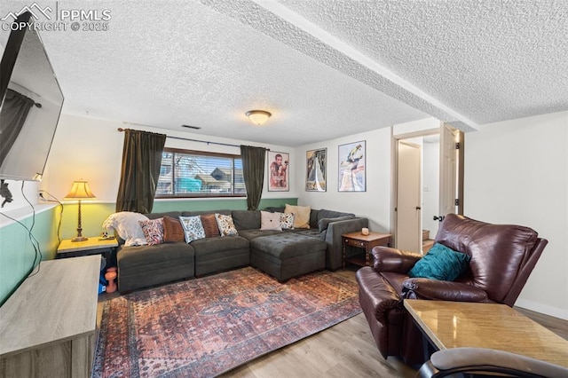 living area with a textured ceiling, wood finished floors, and visible vents