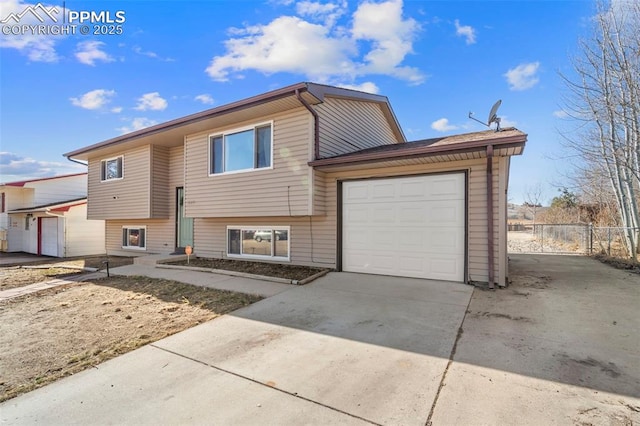 view of front of property with a garage, driveway, and fence