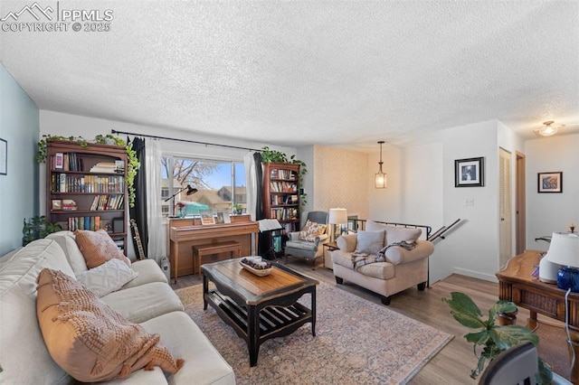 living area featuring light wood-style floors and a textured ceiling