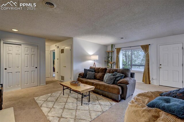 carpeted living room featuring a textured ceiling and visible vents