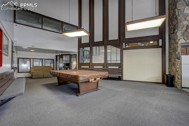 rec room with carpet floors, pool table, and a towering ceiling